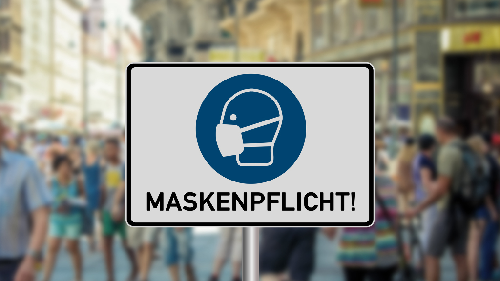 Sie sehen eine eigt ein gezeichnetes Warnschild zum Einhalten der allgemeinen Maskenpflicht.