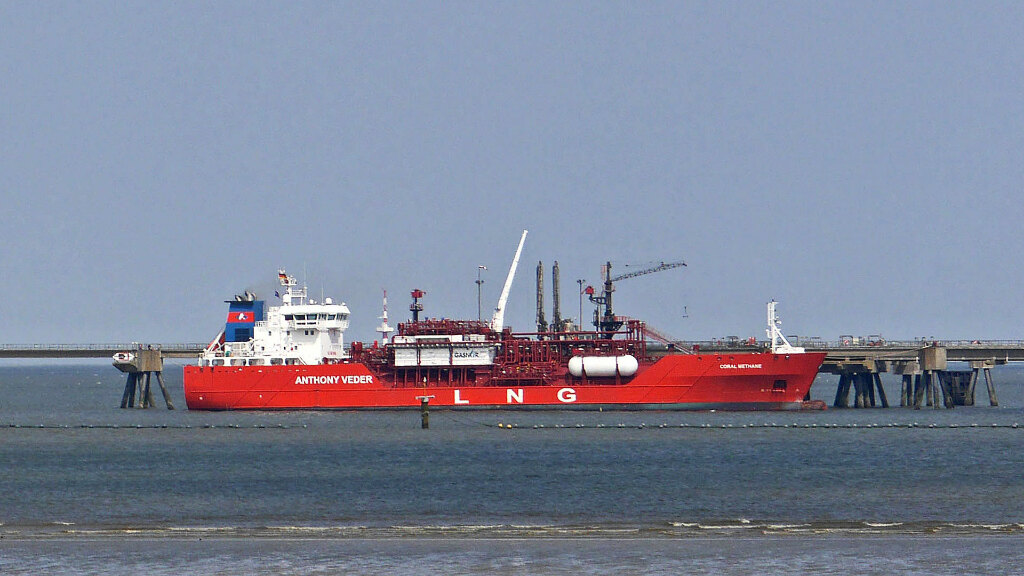 Sie sehen einen Flüssiggastanker, der an einem LNG-Terminal vor Anker liegt.