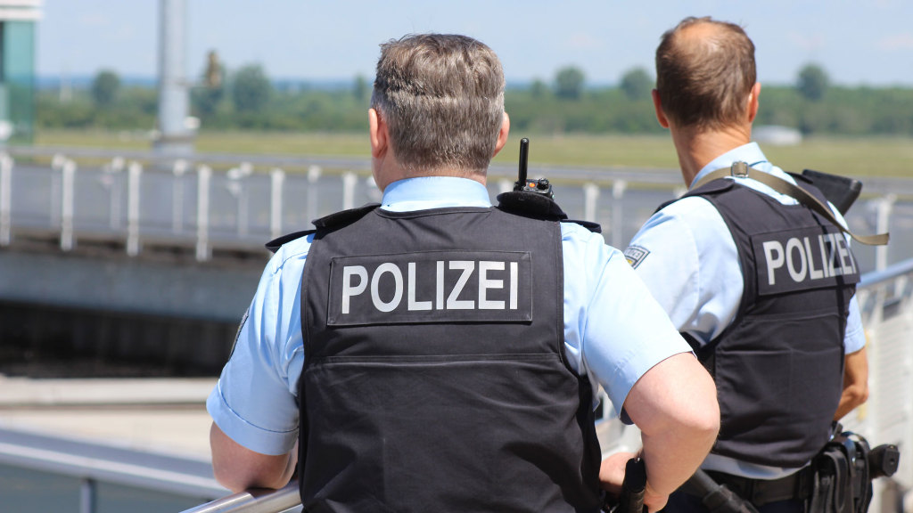 Sie sehen zwei Polizisten mit Schutzwesten.