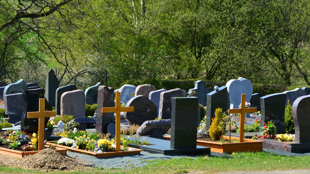 Sie sehen eine Reihe von Gräbern auf einem Friedhof, ein Teil wurde erst neu angelegt.