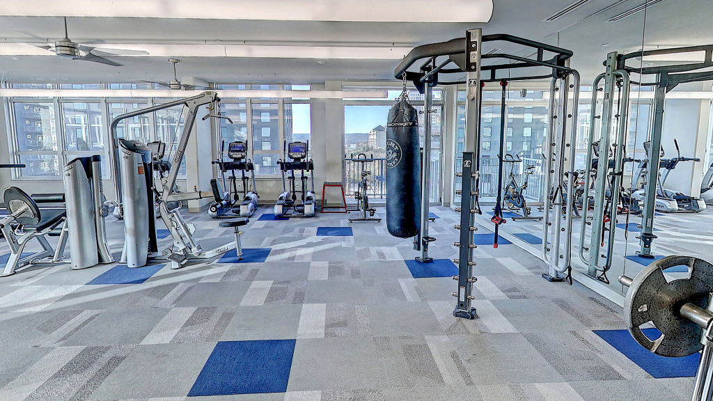 Sie sehen ein Fitnessstudio mit verschiedenen Geräten.