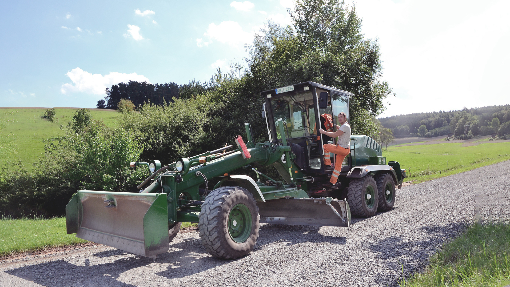 Sie sehen eine große Baumaschine beim Straßenbau.