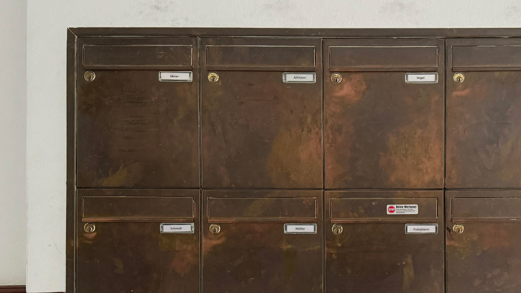 Sie sehen Briefkästen in einem Mehrfamilienhaus.