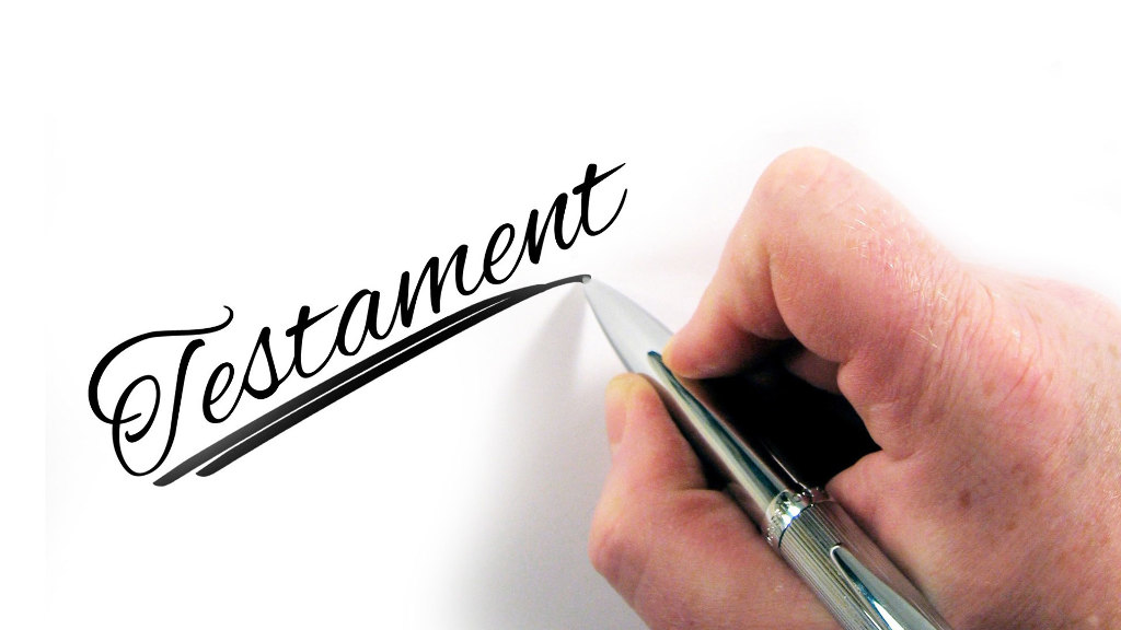 Sie sehen den Schriftzug Testament geschrieben mit einen Stift.