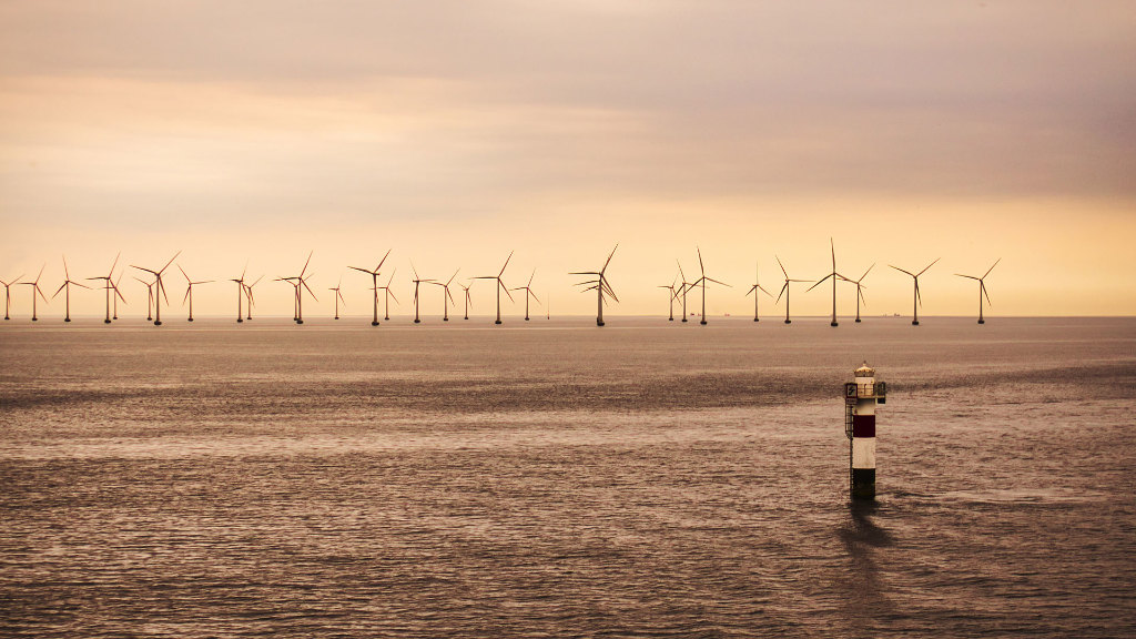 Sie sehen ein Offshore-Windpark auf dem Meer.