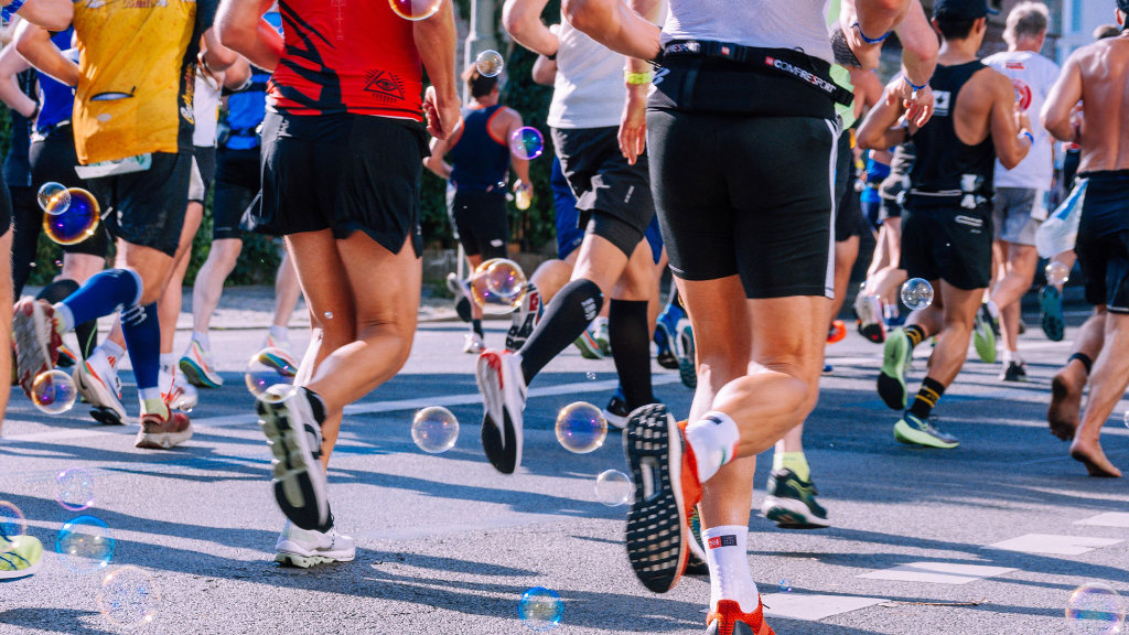 Sie sehen Sportler während einer Laufveranstaltung, wie bspw. einem Marathon.