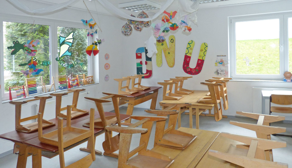 Sie sehen ein leeres Klassenzimmer einer Grundschule mit Stühlen und Tischen.