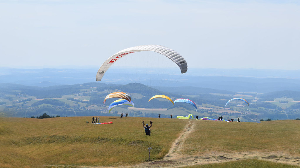 Sie sehen einen Gleitschirmflieger beim Starten.