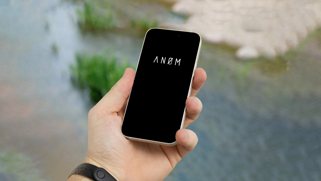Sie ein Smartphone mit einem Logo der ANOM-App auf dem Bildschirm.