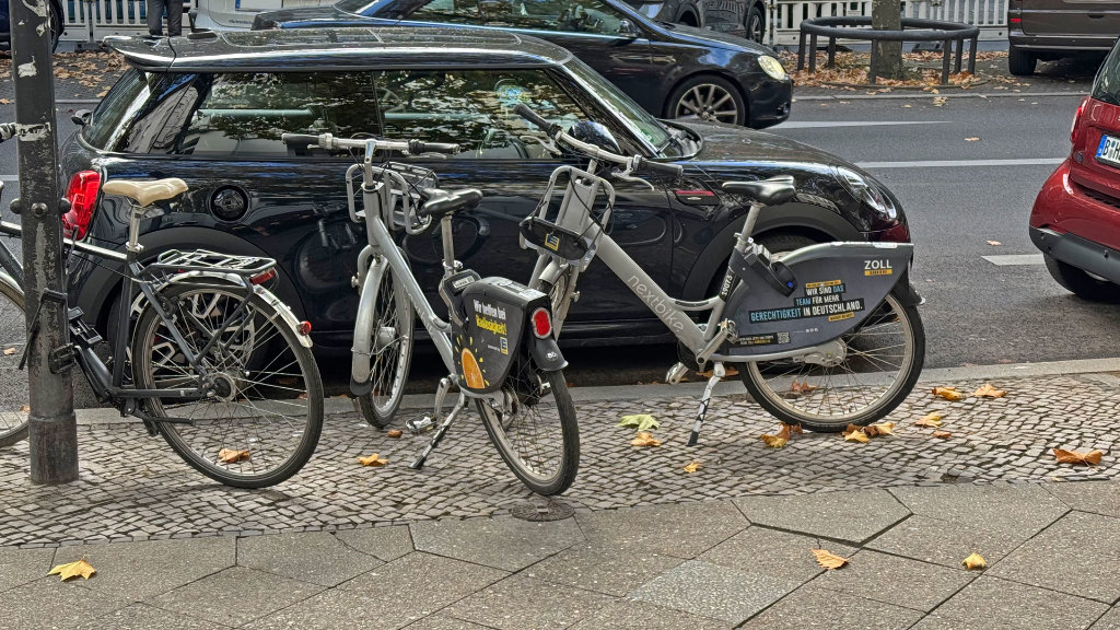 Sie sehen zwei Mietfahrräder auf dem Gehweg.