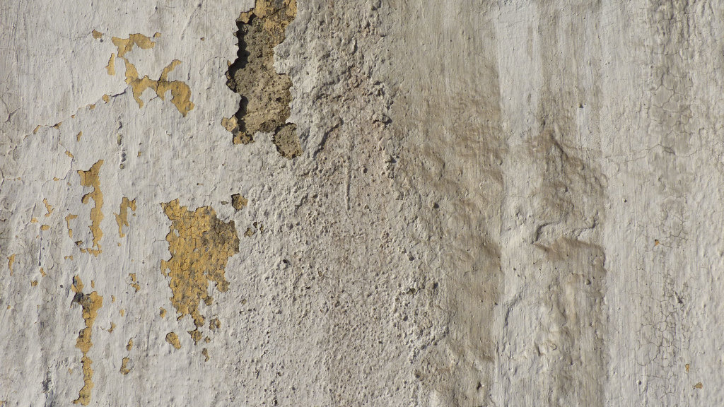 Sie sehen eine Hauswand mit schadhaftem Putz.
