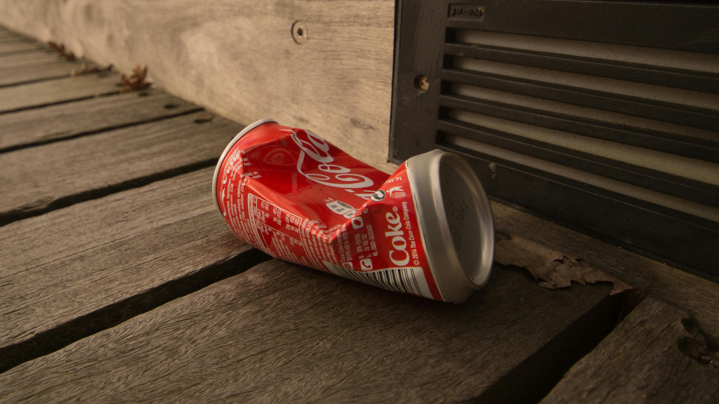 Sie sehen eine zerdrückte Getränkdose am Boden liegen.