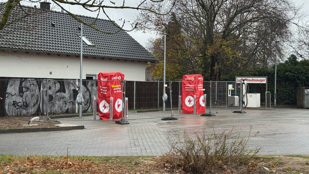 Sie sehen zwei, sich im Bau befindliche Ladesäulen an einer Tankstelle.