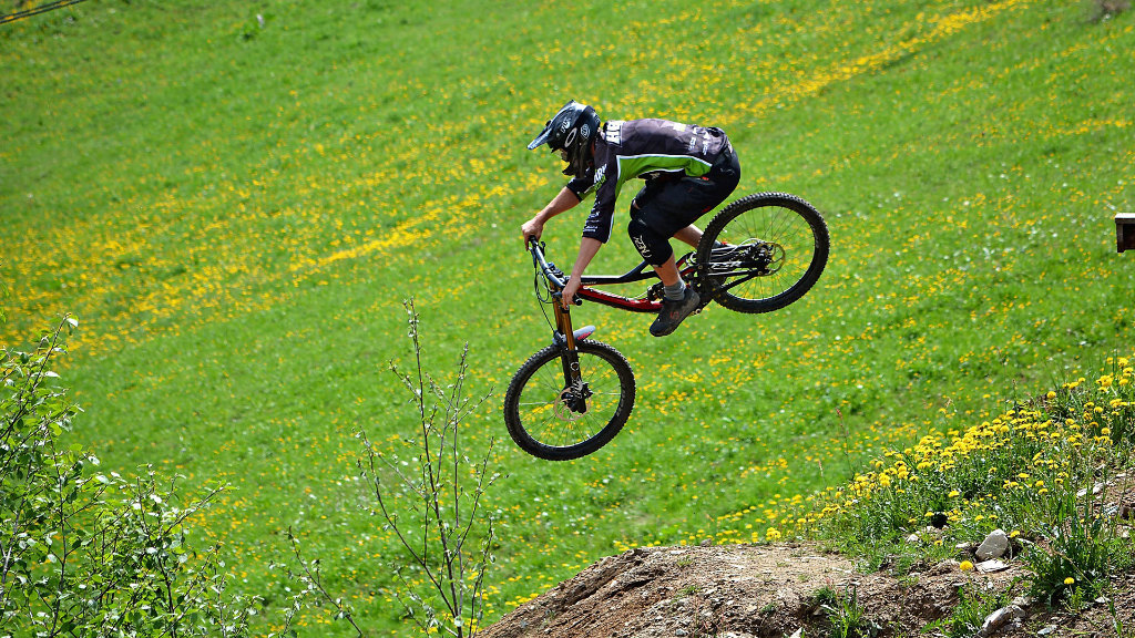 Sie sehen einen Mountain-Bike-Fahrer bei einem Sprung mit seinem Bike.