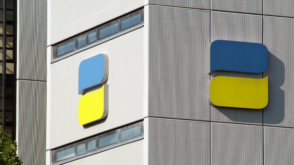 Sie sehen das Logo der Deutschen Rentenversicherung an einer Häuserfassade.