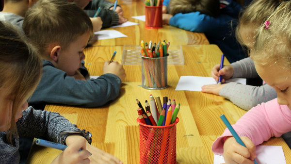 Sie sehen Kindergartenkinder beim Malen.