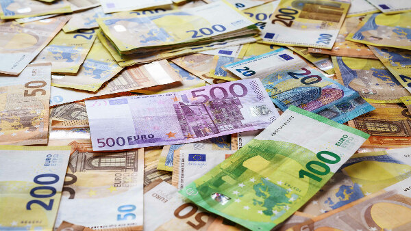 Sie sehen viele verteilte Euro-Banknoten.