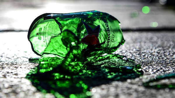 Sie sehen eine zerbrochene Flasche auf dem Boden liegen.