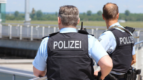 Sie sehen zwei Polizisten mit Schutzwesten.