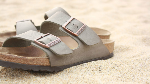 Sie sehen eine Paar Sandalen der Birkenstock am Strand.