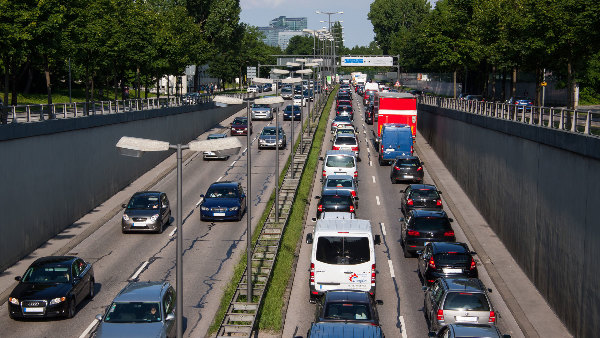 Sie sehen eine Aufnahme des Straßenverkehrs auf einer Schnellstraße in einer deutschen Großstadt.
