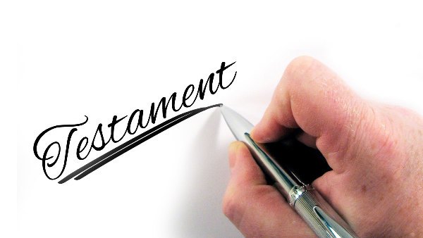 Sie sehen den Schriftzug Testament geschrieben mit einen Stift.