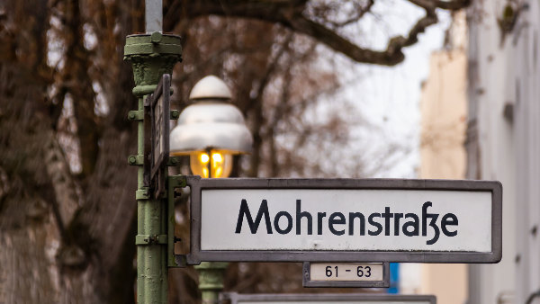 Sie sehen ein Straßenschild mit der Aufschrift „Mohrenstraße“
