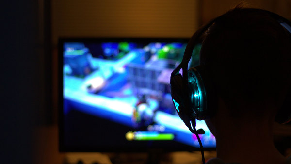 Sie sehen eine Person mit Kopfhörer, die ein Computerspiel spielt.