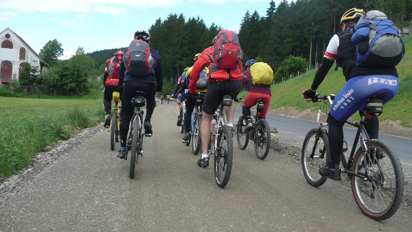 Sie sehen Personen bei einer Fahrradtour.