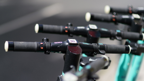 Sie sehen mehrere abgestellte E-Scooter (Elektroroller).