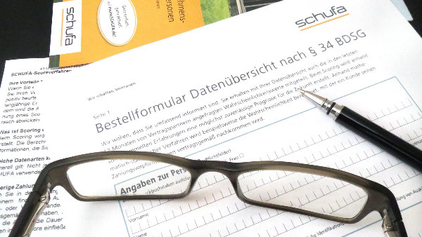 Sie ein Schufa-Formular auf einen Schreibtisch.