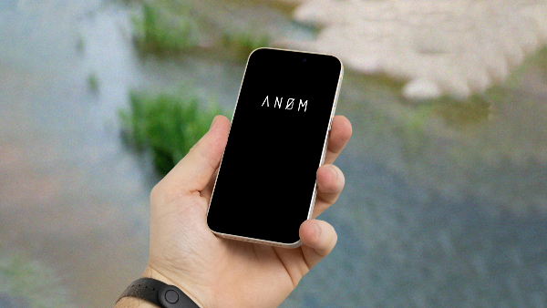 Sie ein Smartphone mit einem Logo der ANOM-App auf dem Bildschirm.