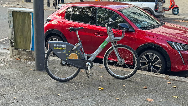 Sie sehen ein Mietfahrrad auf dem Gehweg.