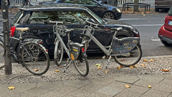 Sie sehen zwei Mietfahrräder auf dem Gehweg.