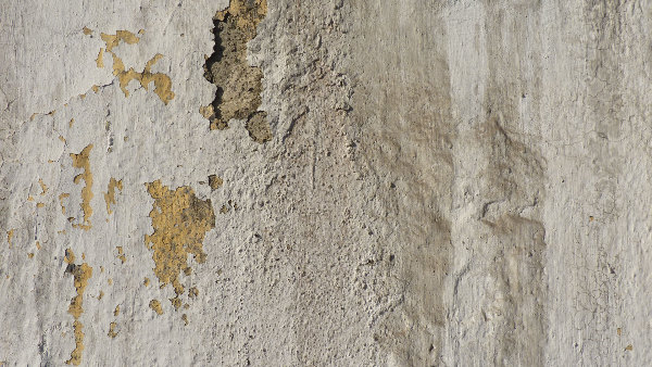 Sie sehen eine Hauswand mit schadhaftem Putz.