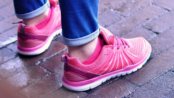 Sie sehen die Sportschuhe, mit denen eine Person auf dem Straßenpflaster steht.