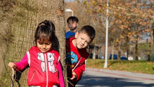 Sie sehen drei spielende Kinder.