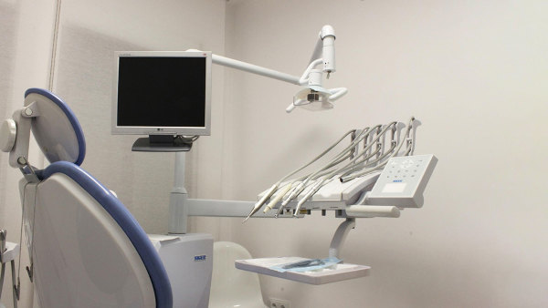 Sie sehen einen Zahnarztstuhl, auf dem kein Patient sitzt.