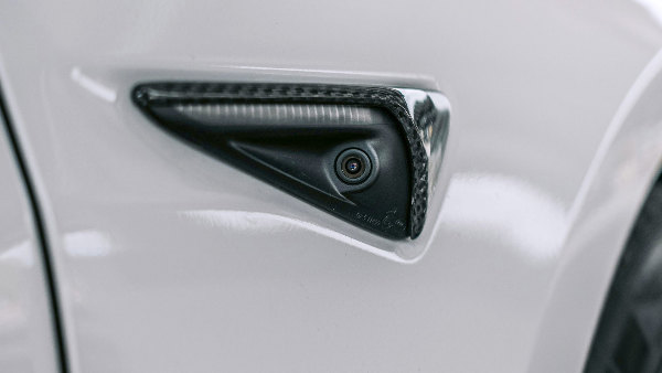 Sie sehen die kaum sichtbare Seitenkamera eines modernen Elektroautos zur Umgebungsüberwachung.