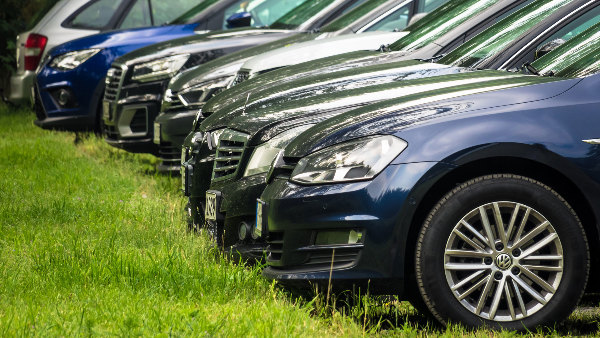 Sie sehen eine Reihe von Autos auf einem Parkplatz.