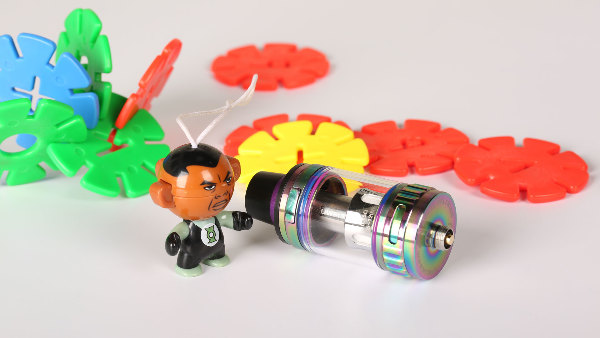 Sie sehen einen Tank für eine E-Zigarette und etwas Spielzeug.