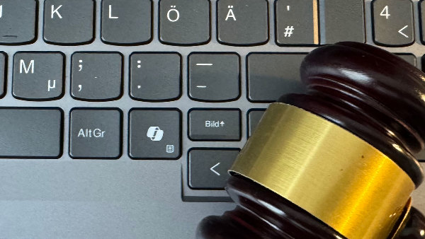 Sie sehen eine Computertastatur, auf der ein Hammer, wie er bei amerikanischen Gerichten üblich ist, liegt.