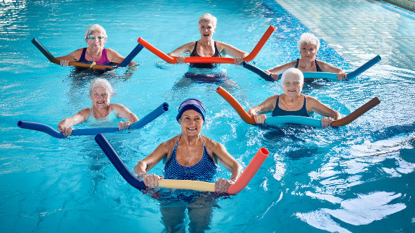 Sie sehen mehrere Personen bei der Wassergymnastik.