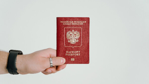 Sie sehen eine Hand, die einen russischen Reisepass hält.
