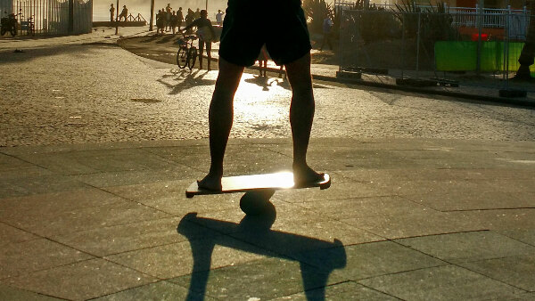 Sie sehen eine Person auf einen Balance Board stehen.