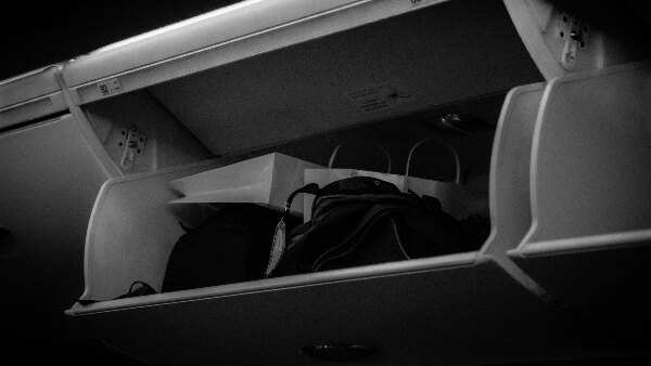 Sie sehen ein Staufach in einem Flugzeug zum Verstauen des Handgepäcks.
