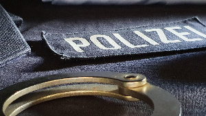 Sie sehen Polzeibekleidung und Handschellen.