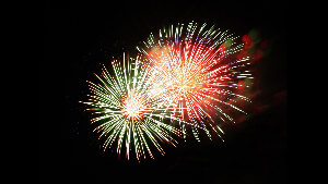 Sie sehen zwei Fontänen von explodierendem Feuerwerk am Nachthimmel.