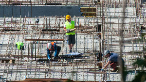 Sie sehen mehrere Bauarbeiter auf einer Baustelle.
