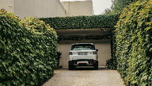 Sie sehen ein Auto vor einer Garage stehen.